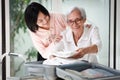 Excited asian senior woman folding clothes into suitcase,Healthy old elderly packing luggage for trip,travel vacation with her Royalty Free Stock Photo