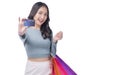 Excited asian showing credit card holding shopping bags in arm standing white background. Cheerful shopper girl using plastic card