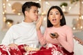 Excited Asian Wife Watching TV Refusing To Kiss Husband Indoors Royalty Free Stock Photo