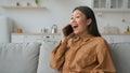 Excited Asian woman businesswoman talk phone in kitchen listen good news feel shock surprised korean chinese girl Royalty Free Stock Photo