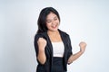 Excited asian woman clenching hands while celebrating success