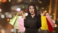 Excited asian woman holding colorful paper bag celebrating Black