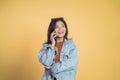 Excited asian woman making a call using a cell phone Royalty Free Stock Photo