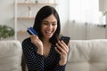 Excited Asian woman triumph shopping on cellphone Royalty Free Stock Photo