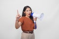 Excited Asian woman wearing a brown shirt showing number one with finger shouting and screaming loud using megaphone speaker. Royalty Free Stock Photo