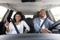 Excited attractive african american millennial couple sitting inside nice car Royalty Free Stock Photo