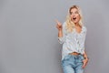 Excited attractive young woman pointing away Royalty Free Stock Photo