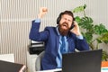 Excited bearded businessman in headphones at workplace. Successful man working in coworking office. Handsome man excited by online Royalty Free Stock Photo