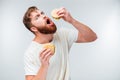 Excited bearded man greedily eating hamburgers