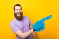 Excited bearded man is pointing aside with the foam fan glove he is wearing. Royalty Free Stock Photo