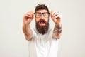 Excited bearded man touching the spectacles and keeping his mouth open against white background. Handsome smart guy with great Royalty Free Stock Photo