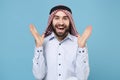 Excited bearded young arabian muslim man in keffiyeh kafiya ring igal agal casual clothes isolated on pastel blue