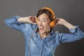 Excited beautiful middle aged woman laughing with funky music on