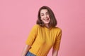 Excited beautiful woman with mouth open wearing casual yellow t-shirt isolated on pink background