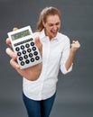 Excited beautiful young woman winning money in holding symbolic calculator