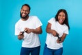 Excited black couple playing video games together with joysticks Royalty Free Stock Photo