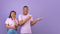 Excited black couple pointing aside at free copy space, panorama Royalty Free Stock Photo