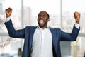 Excited black entrepreneur clenching his fists.