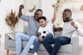 Excited black grandfather, dad and son cheering favorite football team at home Royalty Free Stock Photo