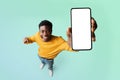 Excited black guy demonstrating smartphone with blank white screen, showing free copy space for your ad, mockup Royalty Free Stock Photo