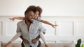 Excited black man giving piggyback ride to happy cute daughter. Royalty Free Stock Photo