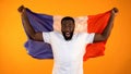 Excited black man holding French flag, supporting national sports team, cheering Royalty Free Stock Photo