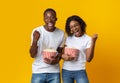 Excited black man and woman eating popcorn, watching movie Royalty Free Stock Photo