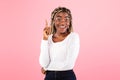 Excited black woman has great idea and points finger up Royalty Free Stock Photo