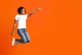 Excited black woman jumping up and showing copy space