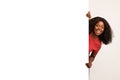 Excited Black Young Lady Peeking Out Of Blank Advertisement Board Royalty Free Stock Photo