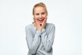 Excited blonde woman open mouth feels astonishment touch face with hands Royalty Free Stock Photo