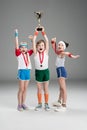 Excited boy and girls with medals and champion goblet