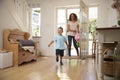 Excited Boy Returning Home From School With Mother