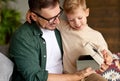 Excited boy son receiving gift box from young loving father on holiday Royalty Free Stock Photo