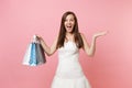 Excited bride woman in white wedding dress spread hands hold multi colored packages bags with purchases after shopping Royalty Free Stock Photo
