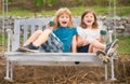 Excited brother and sister swinging on swing in spring park outdoors. Little boy and girl kids enjoying spring. Kids Royalty Free Stock Photo