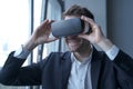 Excited business person in suit wearing VR headset on head taking part in meeting in virtual reality Royalty Free Stock Photo