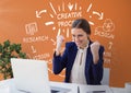 Excited business woman at a desk looking at a computer against orange background with graphics Royalty Free Stock Photo