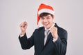 Excited businessman in black suit and santa hat isoalted on whit Royalty Free Stock Photo