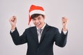 Excited businessman in black suit and santa hat isoalted on whit Royalty Free Stock Photo