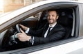 Excited businessman driving car to airport, going on business trip Royalty Free Stock Photo