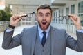 Excited businessman holding two pair of eyeglasses