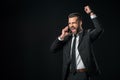 excited businessman in jacket celebrating while talking on smartphone Royalty Free Stock Photo