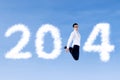 Excited businessman jumping with clouds of 2014 Royalty Free Stock Photo