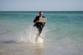 Excited businessman in wet suit run in sea. Funny business man, crazy comic business concept. Remote online working