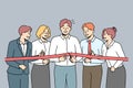 Excited businesspeople cut ribbon together