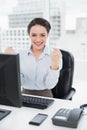 Excited businesswoman clenching fists at office desk Royalty Free Stock Photo