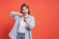 Excited casual young woman playing video games having fun on red background Royalty Free Stock Photo