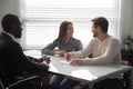 Excited Caucasian clients closing deal at biracial agent office Royalty Free Stock Photo