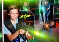 Excited boy aiming laser gun at other players during laser tag g Royalty Free Stock Photo